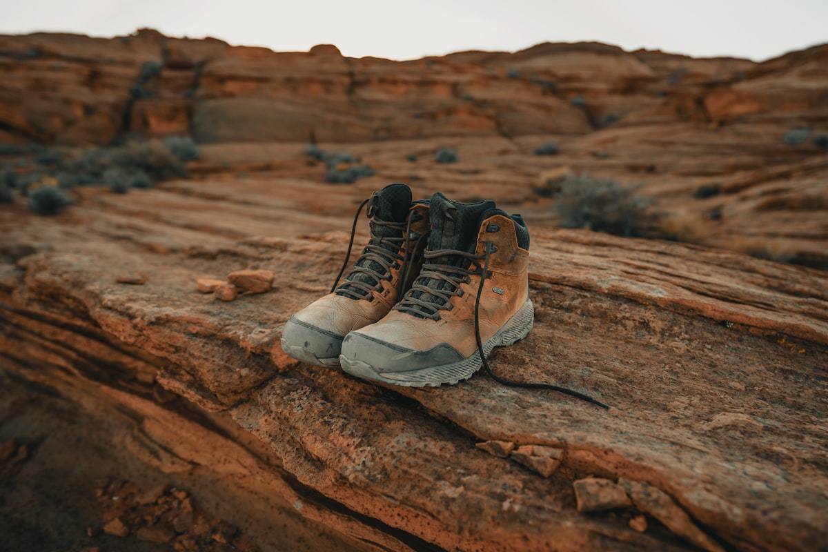 Pair of mid-cut hiking boots on red rock terrain